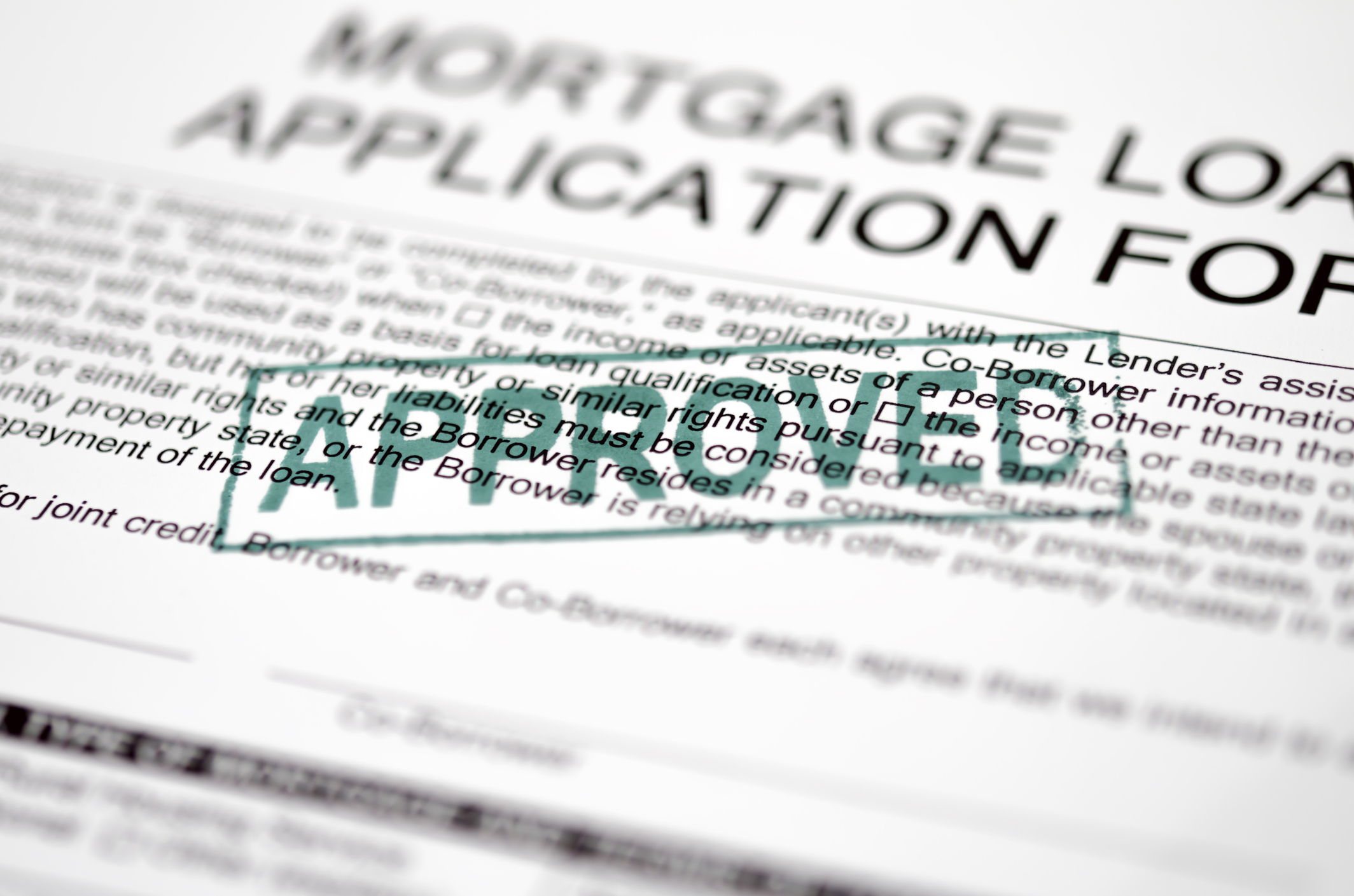 Mortgage loan application with approved stamped on top.