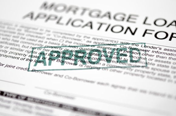 Mortgage loan application with approved stamped on top.