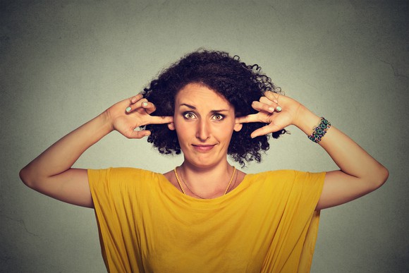 Woman plugging her ears with her fingers
