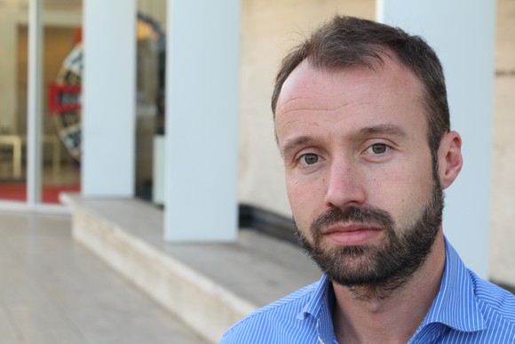A bearded man staring at the camera with a serious expression