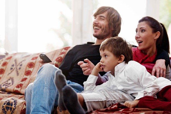 Family on a couch, watching TV