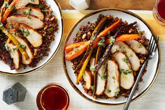 Two plates on a table featuring a meal with pork and vegetables