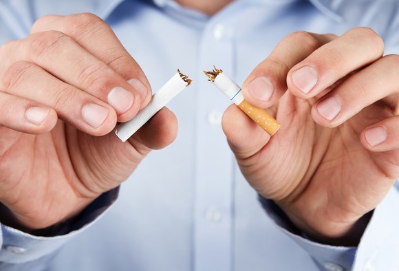 Man breaking a cigarette in half