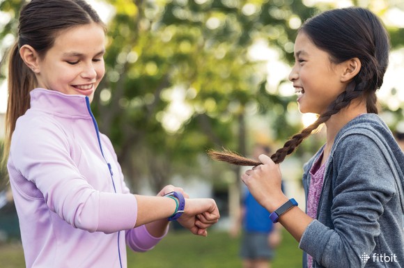 Two girls wears Fitbit Ace smartwatches