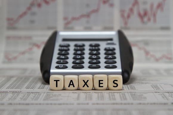 Calculator with the word taxes spelled out in tiles in front of it