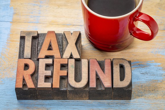 The words tax refund in wooden block letters next to a coffee mug