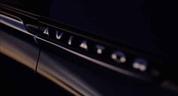 A teaser image on a vehicle exterior showing "Aviator".