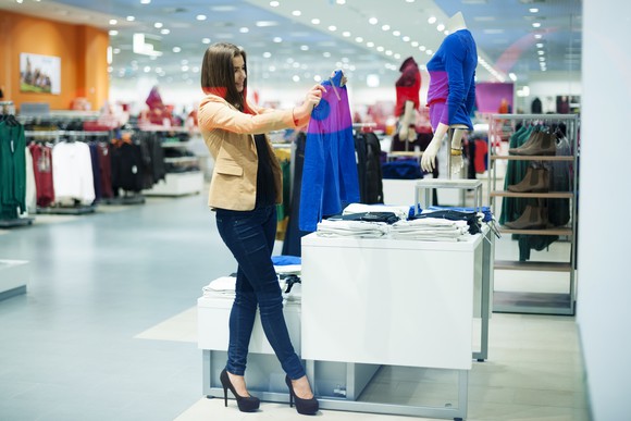a young woman shops for clothes in a mall-like setting.