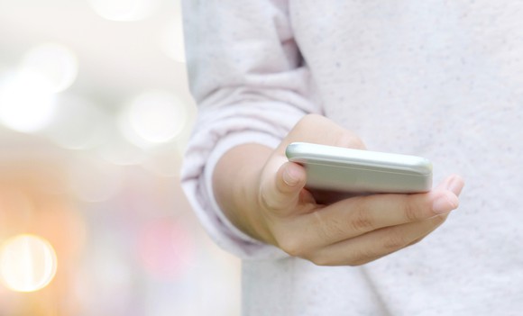 A person holds a smartphone in their hand.