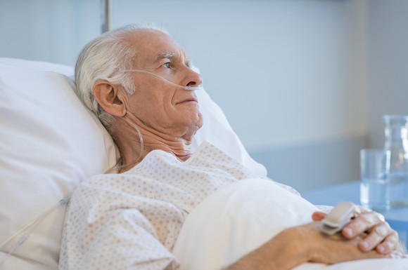Senior man lying in bed with oxygen tube