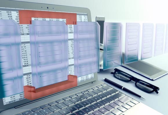 Computer showing spreadsheet numbers, with glasses and pen next to it.