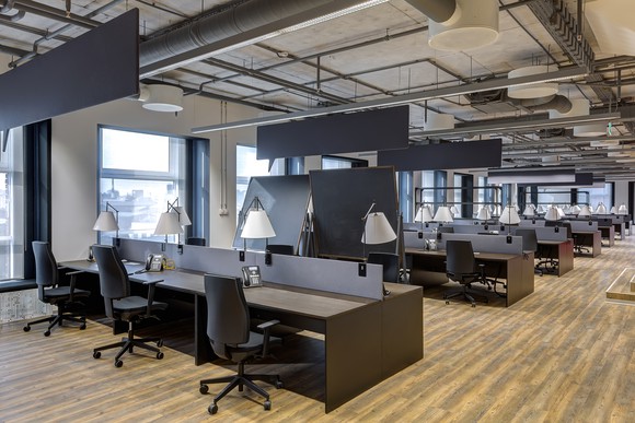 Rows of workspaces in a modern, open office.