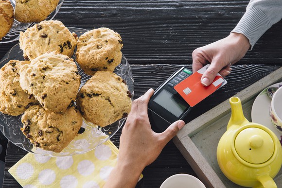 A customer makes a purchase using a contactless credit card reader.