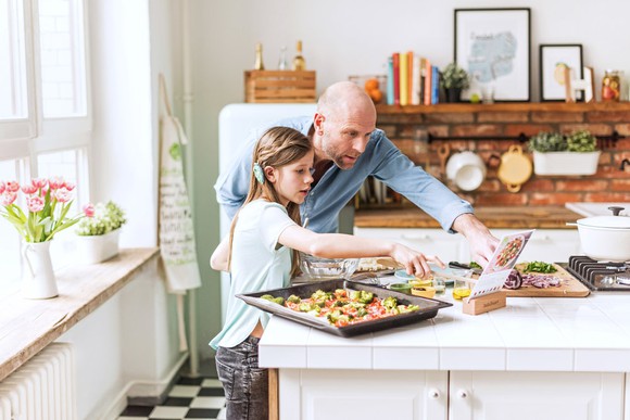 A man and young girl preparing a HelloFresh meal kit