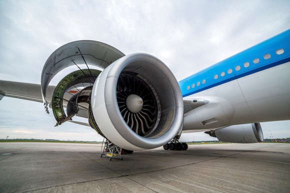 A jet engine on the tarmac, open for inspection.