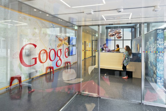 An entrance to an office with a glass wall and the Google logo.