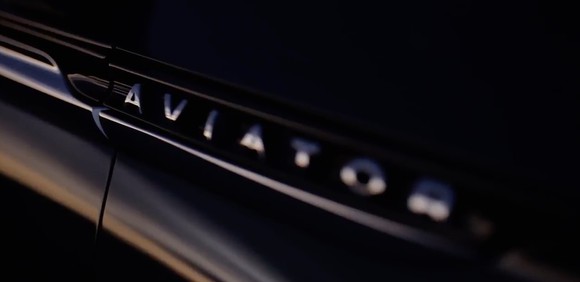 A "teaser" image showing the Aviator logo visible on the side of a black vehicle.