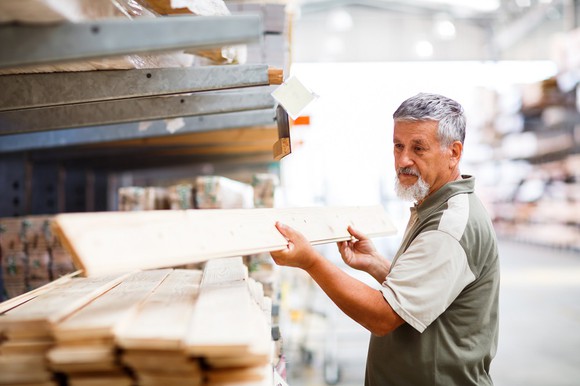 Man selecting lumber in a home-improvement store.