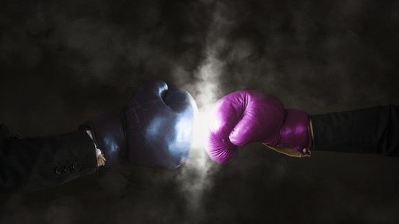 Two business people wearing boxing gloves