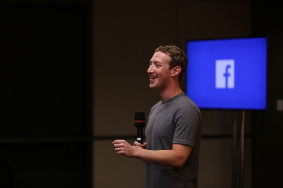 Mark Zuckerberg standing, speaking into a microphone.