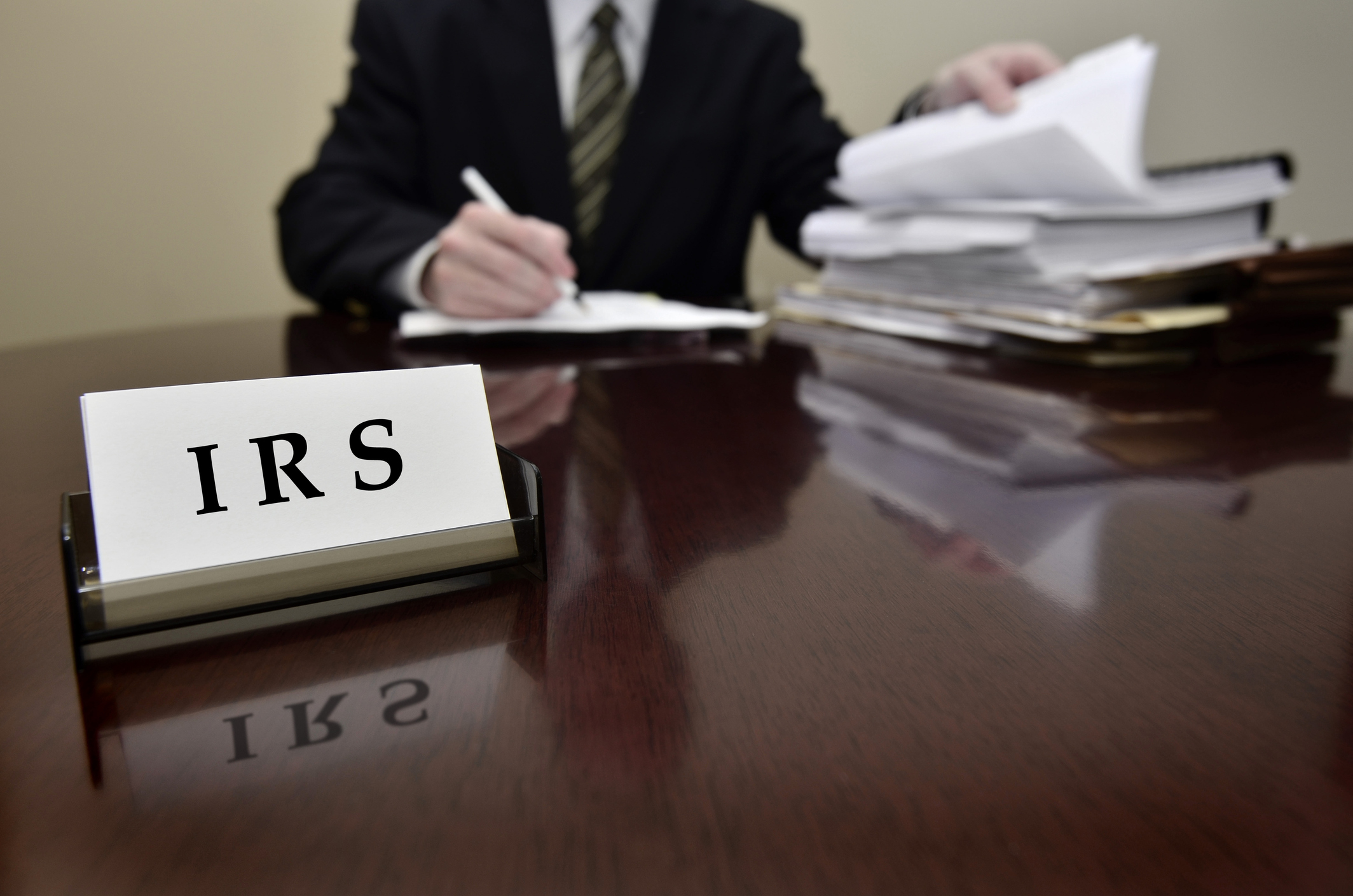 An IRS tax agent examining returns at his desk.