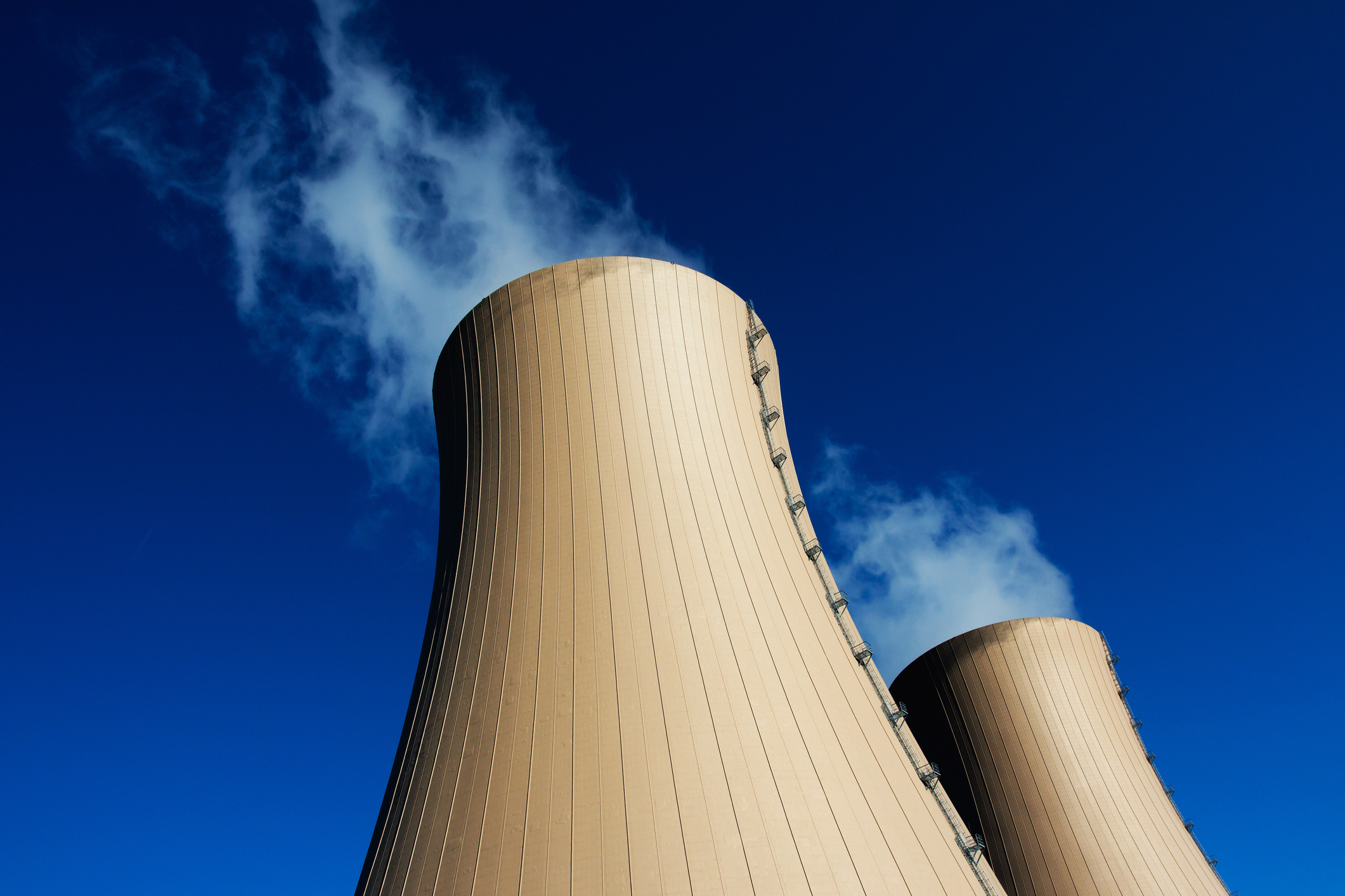 Cooling towers for a power plant against a blue sky.