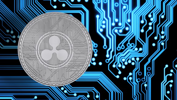 A silver physical Ripple coin surrounded by circuitry.