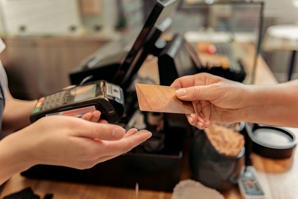 Bakery customer paying merchant with gold credit card.
