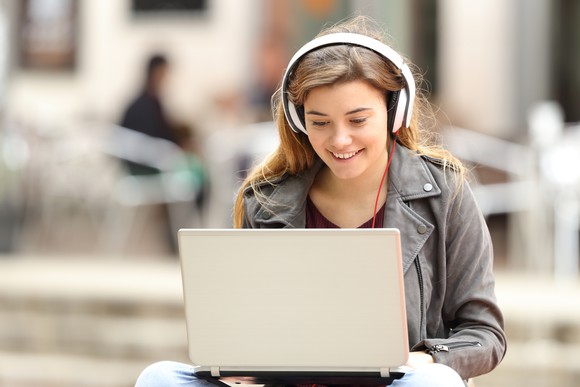 A girl listens to music using headphones.
