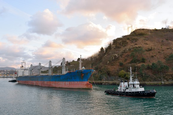 Tugboat pulling cargo ship