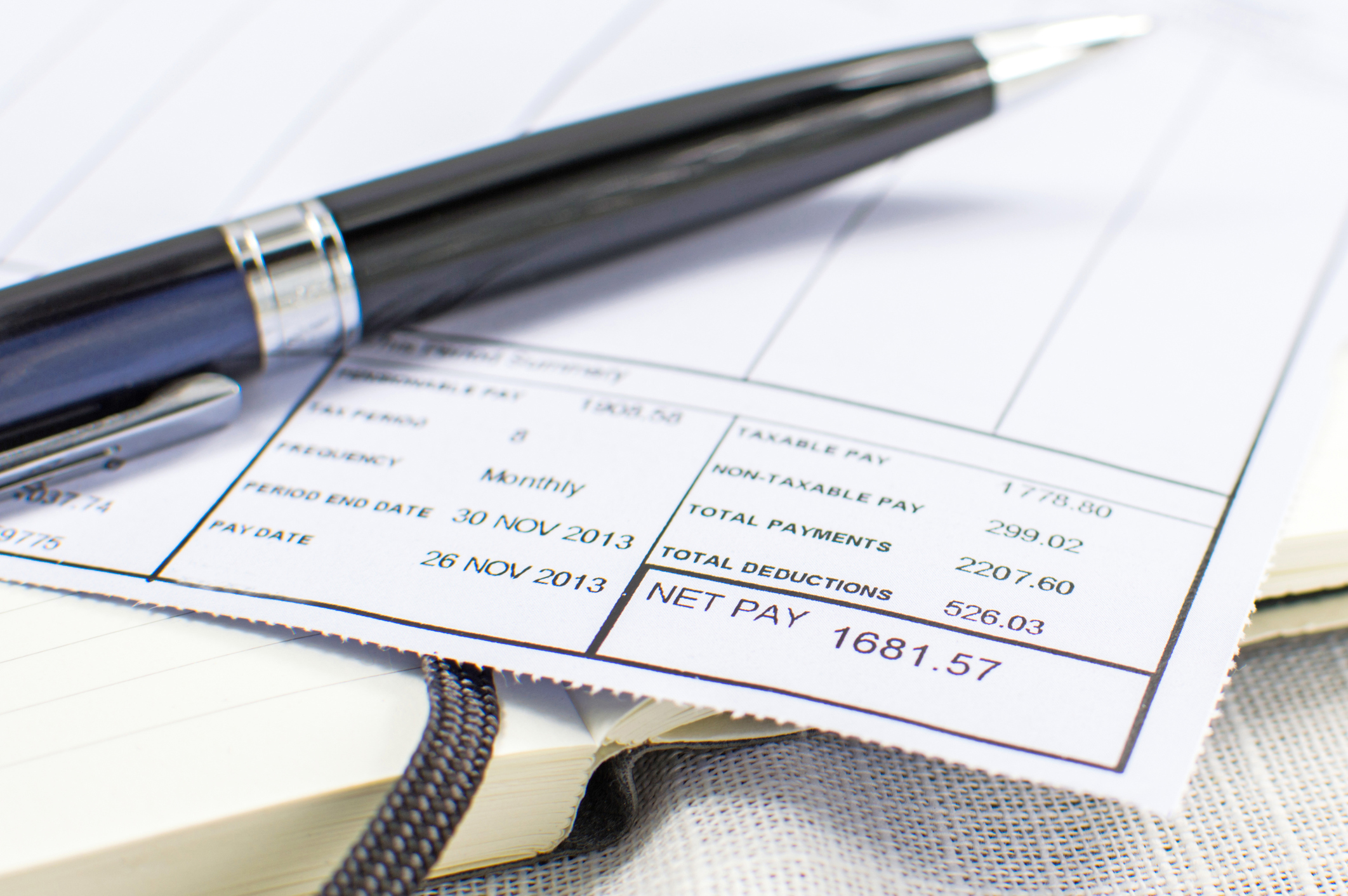 Paycheck stub with pen on top.