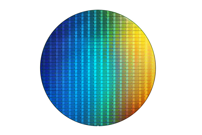 A wafer of Intel processors colored blue, green, and yellow from right to left.