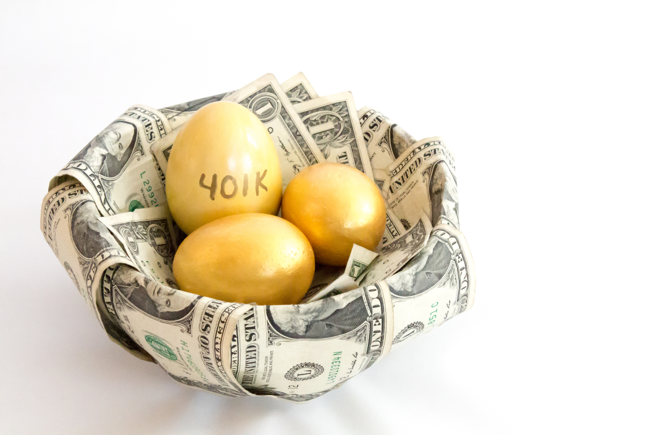 Three gold eggs, one labeled 401k, in a nest-shaped bowl of one dollar bills.