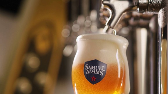 Beer glass with Samuel Adams logo being filled at a tap