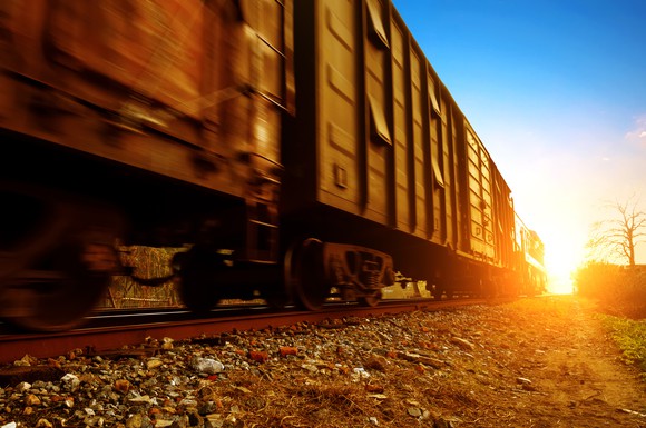 A freight train with the sun setting in the background.