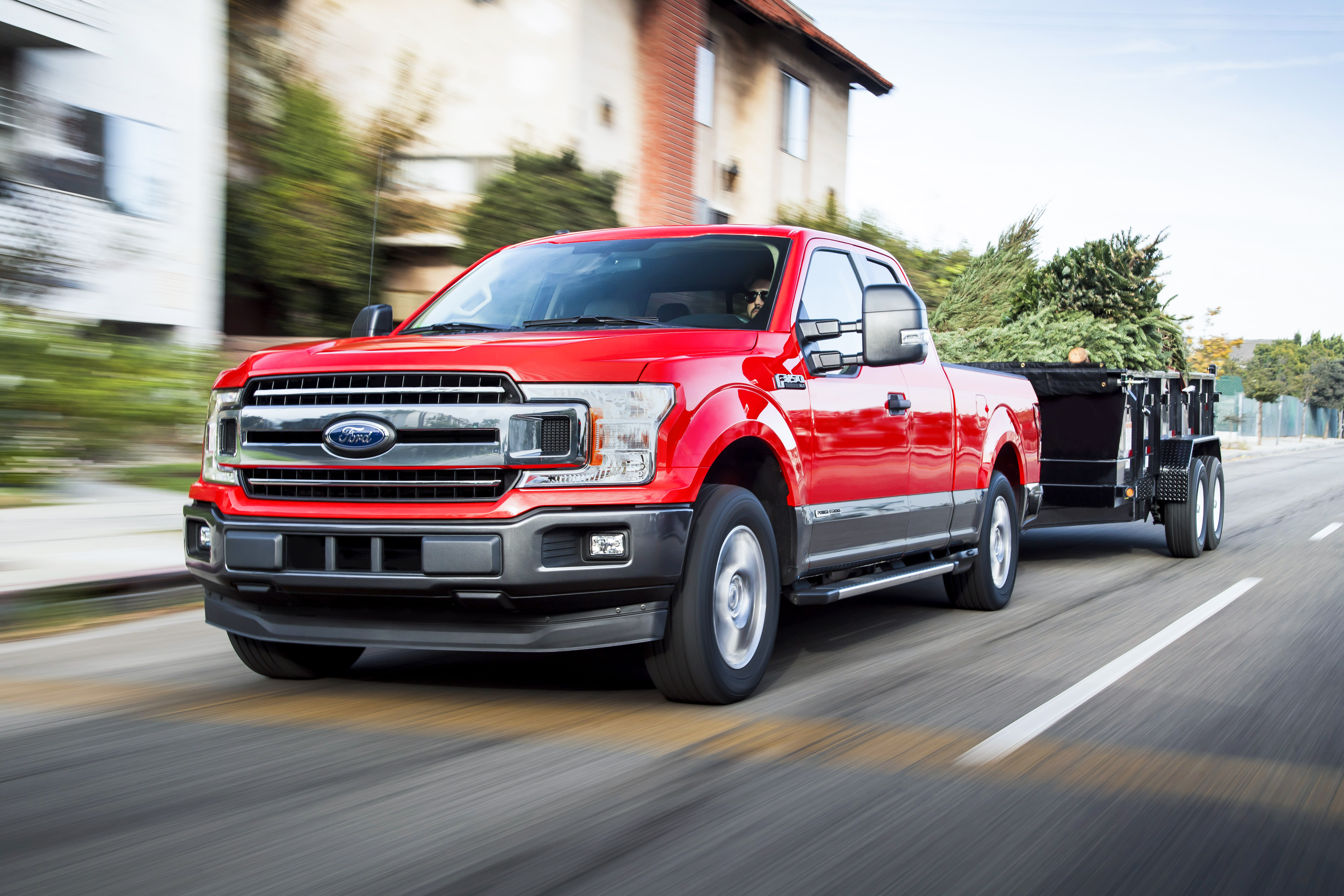 A red Ford F-150 diesel-powered pickup truck is shown pulling a trailer.