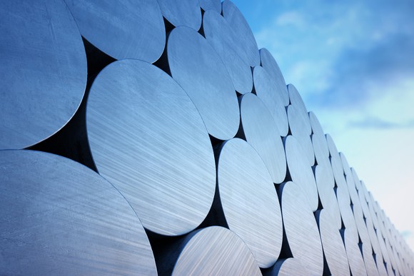 Aluminum rolls stacked against a blue sky