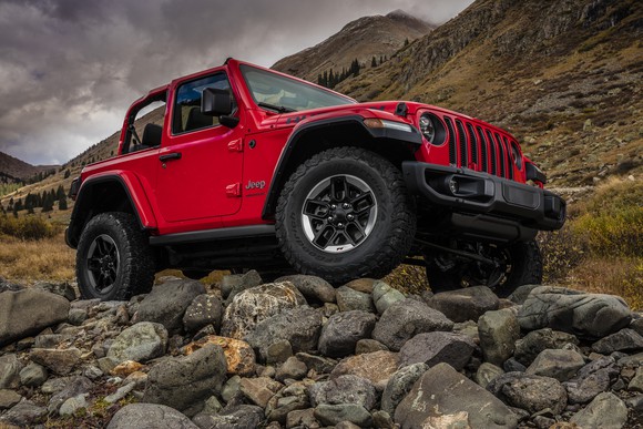 A red 2018 Jeep Wrangler SUV is shown atop a very rocky hill.