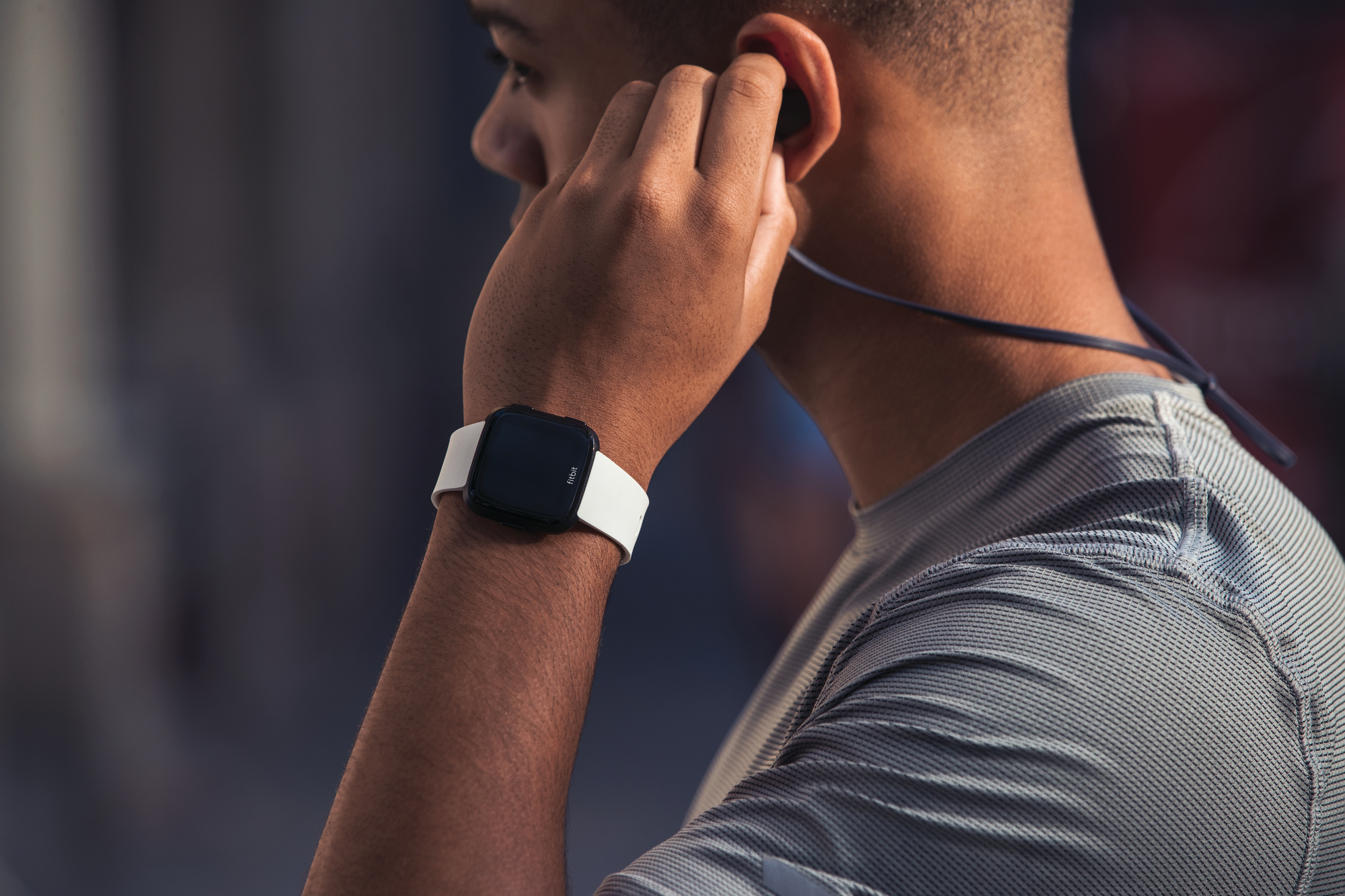 Man in workout gear wearing a Fitbit Versa Smartwatch