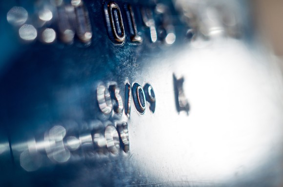 Close-up of credit card showing a partial number and name.