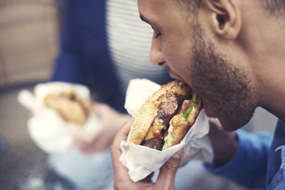 A man eats a cheeseburger.