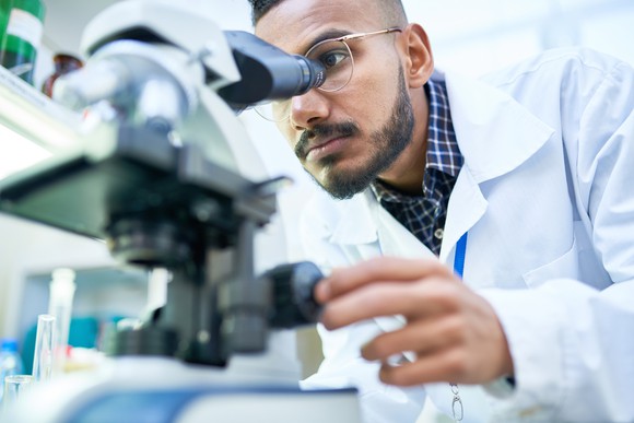 Scientist looking into a microscope.