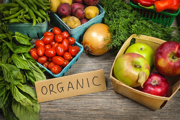 Assorted fruit and vegetable on a table with a label that says "organic."