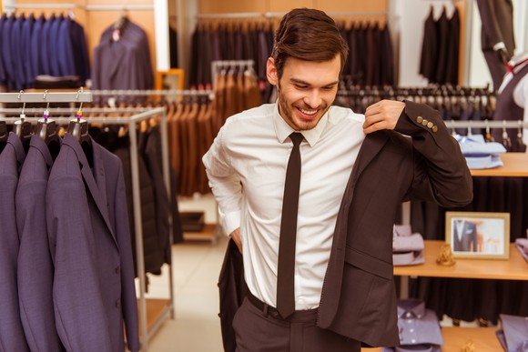 A man trying on a suit inside a suit shop