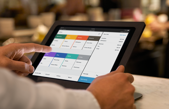 A person using Square for Restaurants on a tablet.