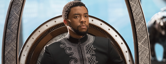 Black Panther's King T'Challa sitting on the Wakandan throne.