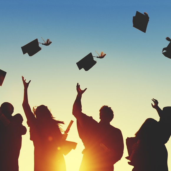 Graduates throwing graduation hats in the air.