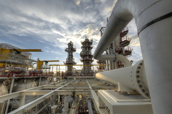 An energy processing plant with clouds in the background.