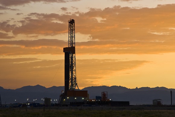 A drilling rig with a sunset in the background.