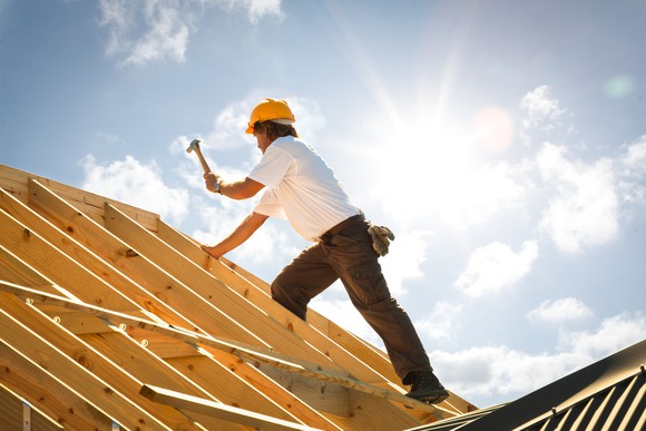 Construction worker hammering a roof